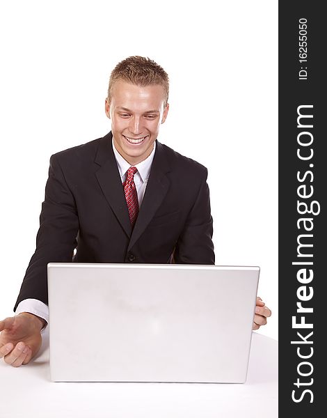 A young man looking at his computer with a happy expression on his face. A young man looking at his computer with a happy expression on his face.