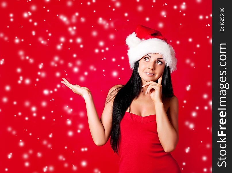 Beautiful happy young woman dressed as santa with her hand up, place your product here