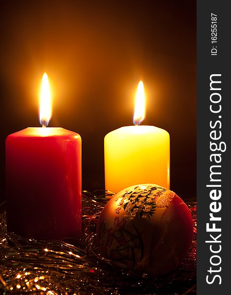 Group of two candles and glass fur-tree sphere in darkness. Group of two candles and glass fur-tree sphere in darkness