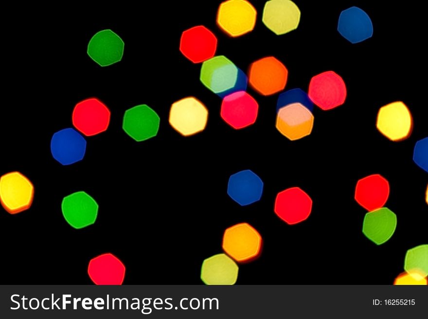 Multi-coloured polygonal stains are randomly scattered on a black background. Multi-coloured polygonal stains are randomly scattered on a black background