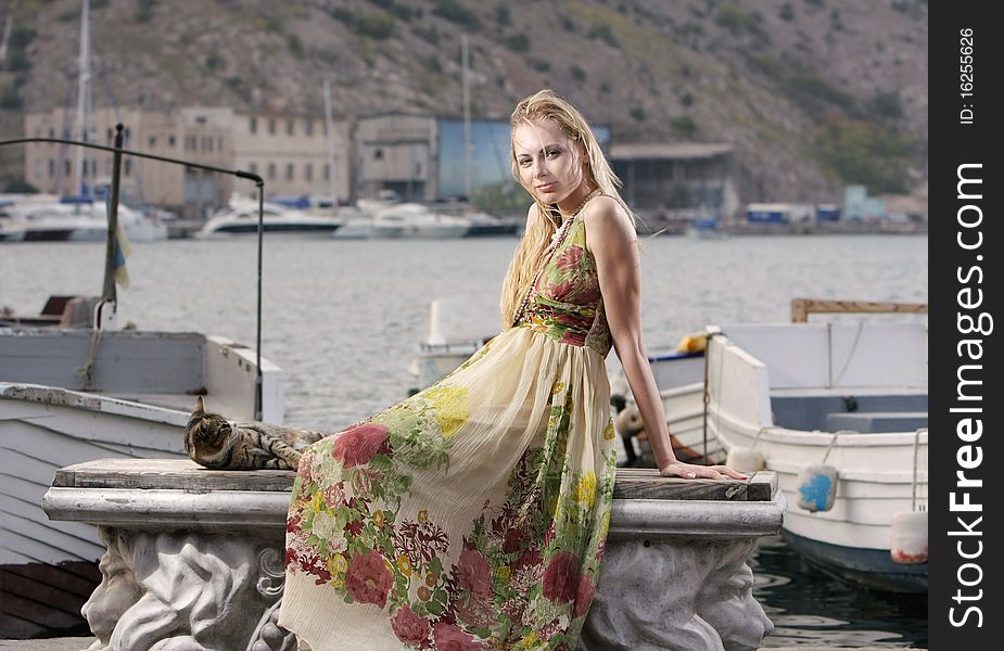 Young attractive woman sitting on pier background. Young attractive woman sitting on pier background