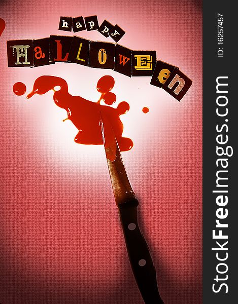 Bloody knife highlighted on a happy halloween background