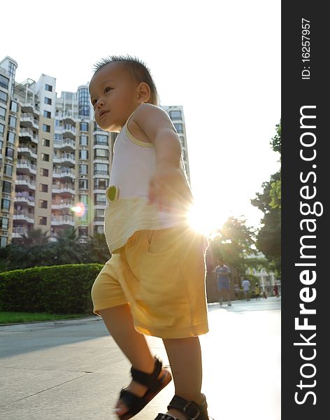 A Chinese boy is walking on the outdoor, and the sun light is through his back. Back-lighting photography. A Chinese boy is walking on the outdoor, and the sun light is through his back. Back-lighting photography.