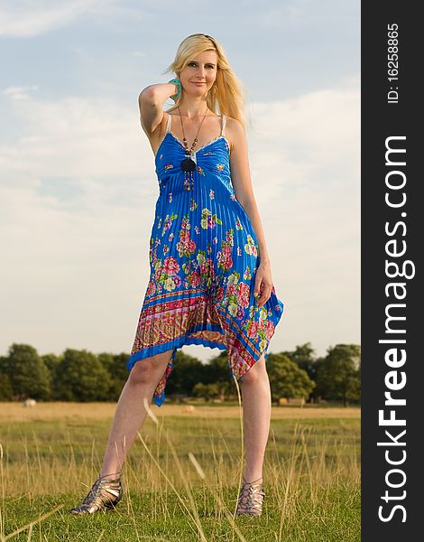 A young woman posing in a field looking beautiful. A young woman posing in a field looking beautiful