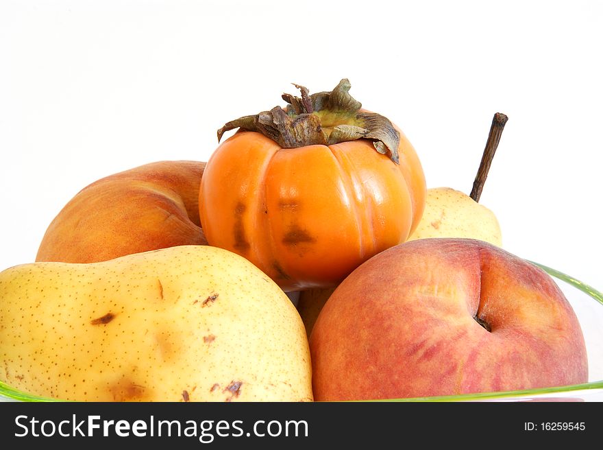 Still life, natural persimmon, pear and peach on a white background
