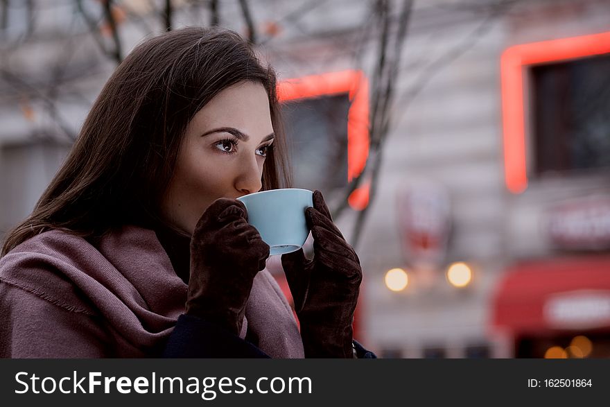 A Woman Drinking Coffee Outdoors