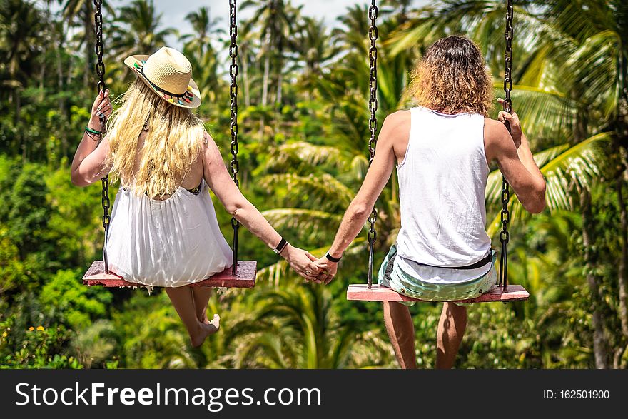 Couple swinging in the jungle