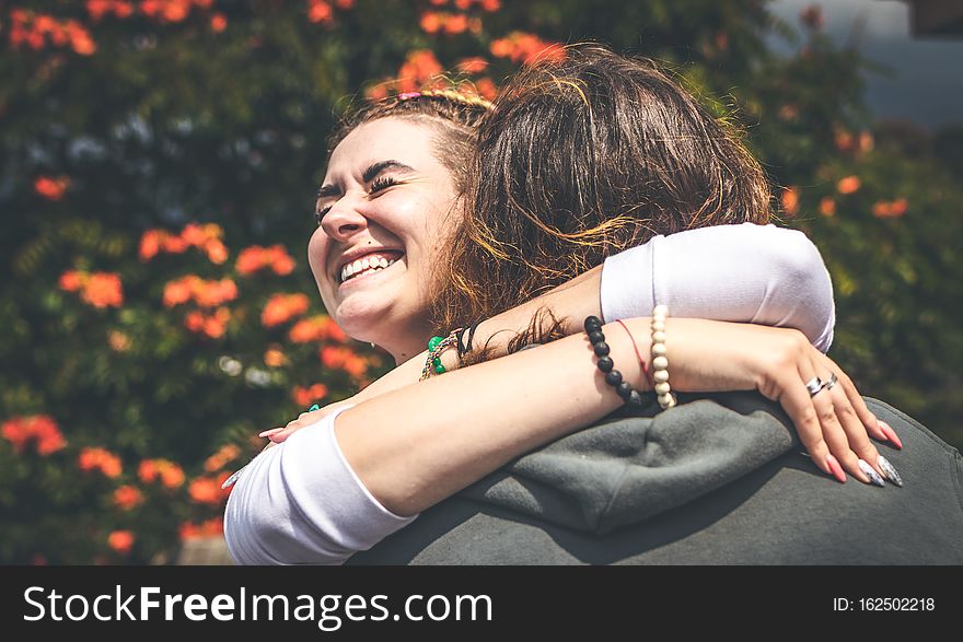 Cheerful Smiling Couple In Love Hugging In Nature On A Beautiful Flower Background. Bali Island.