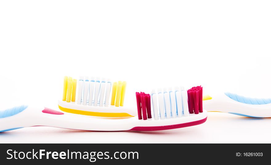 Red and yellow toothbrushes isolated on white