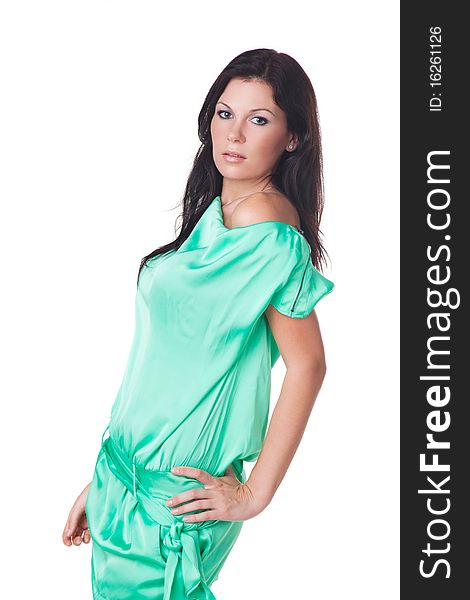 Beautiful brunette model in green dress on a white background