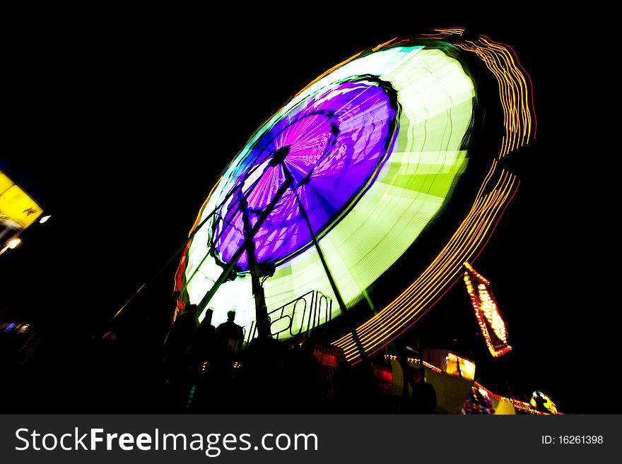 Circular and brightly lit county fair ride at night. Circular and brightly lit county fair ride at night