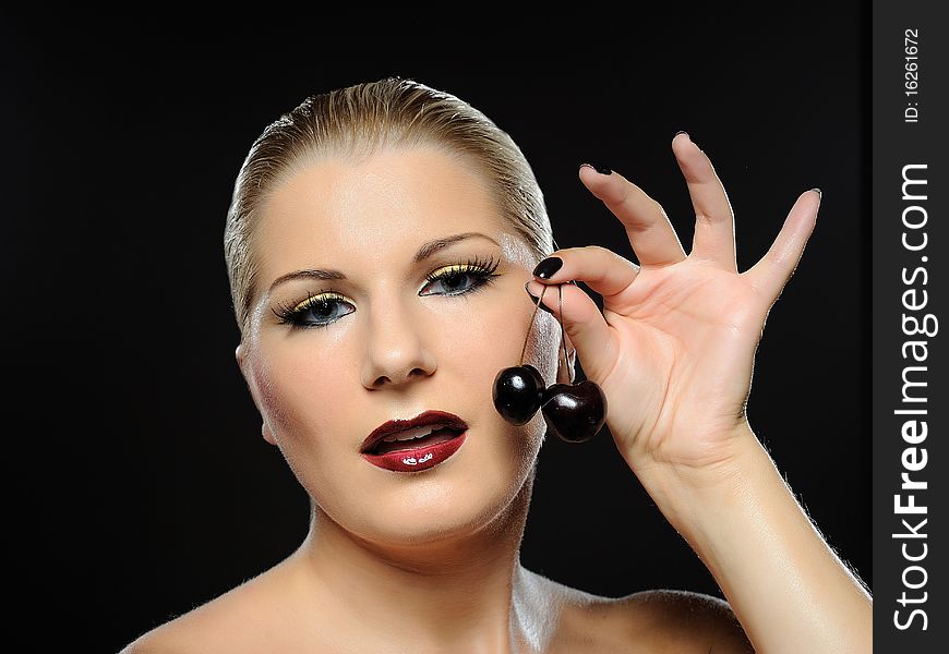 Beautiful woman with bright make-up holding cherries. Beautiful woman with bright make-up holding cherries