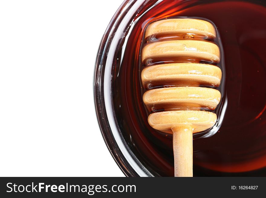 Honey in glasswares with wooden honey dipper.