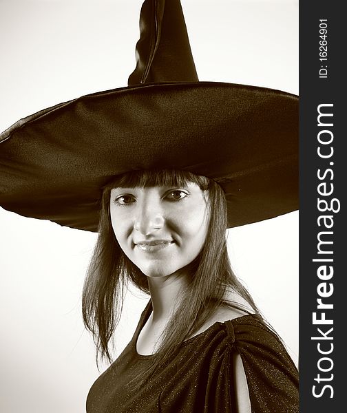 Young witch in a pointy hat in sepia