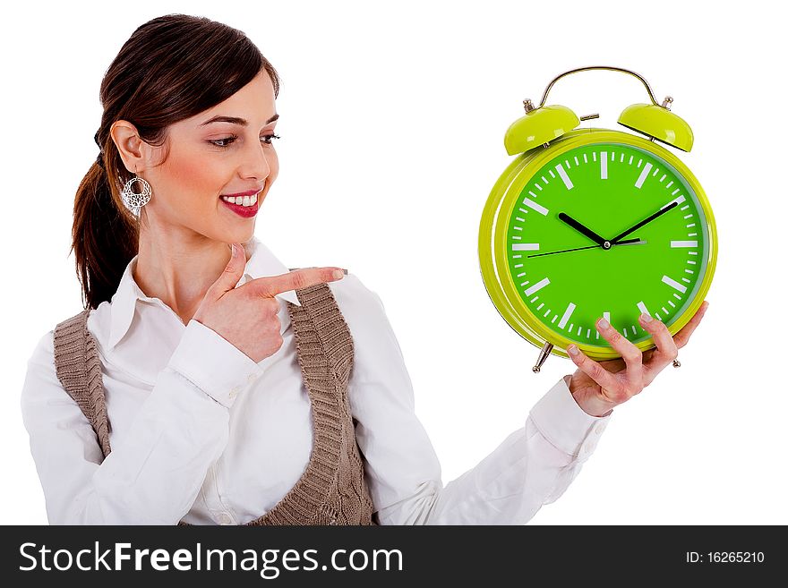 Half view of lady holding alarm clock and pointing at it on an isolated white background. Half view of lady holding alarm clock and pointing at it on an isolated white background