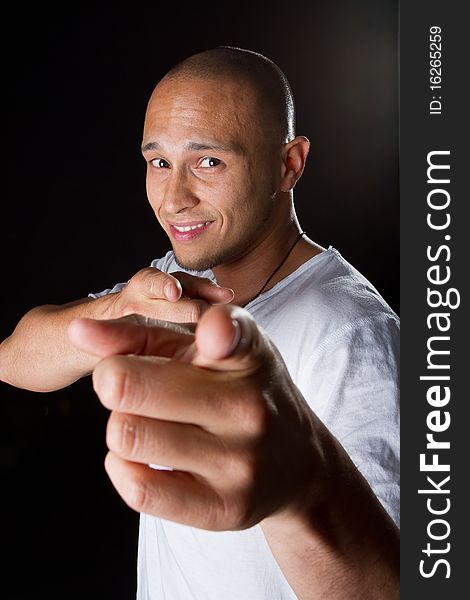 Young male filipino model over a black background is gesturing with his hand. Young male filipino model over a black background is gesturing with his hand.