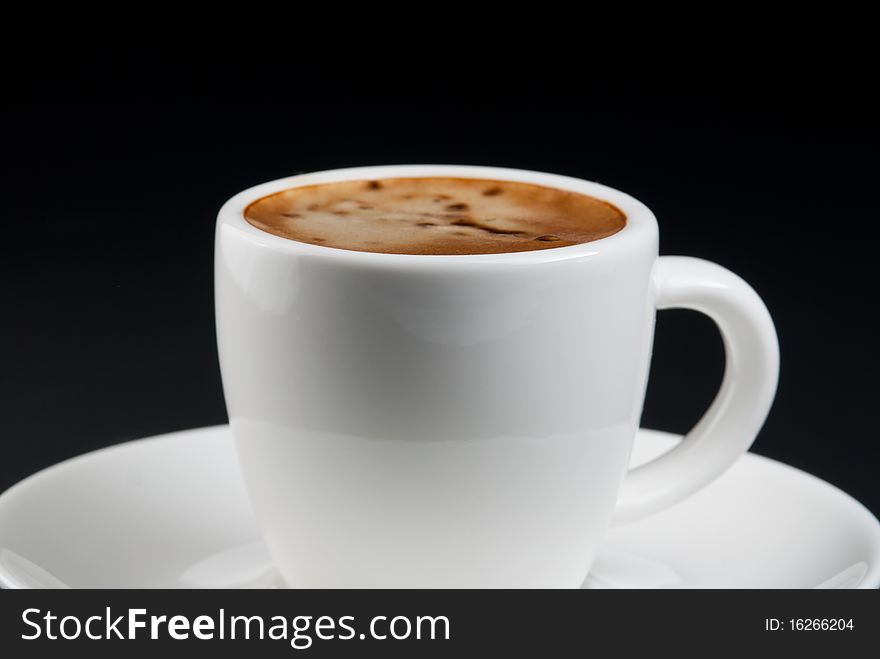 Coffee in white cup - Coffee with mousse in white cup on black background.