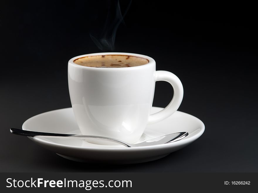 Hot coffee in white cup on black background.