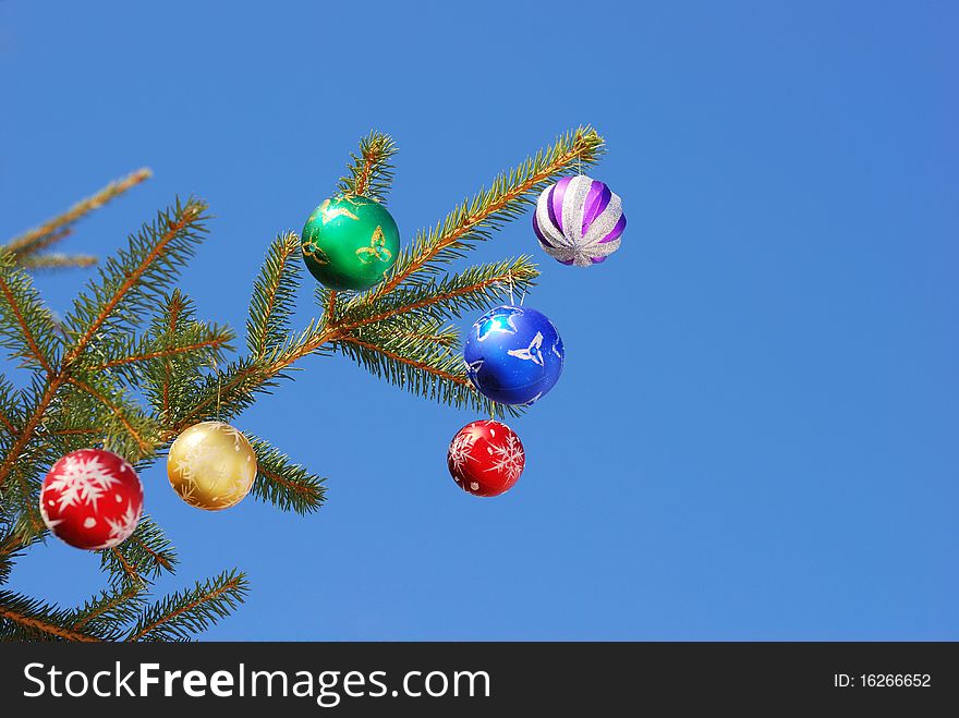 Christmas and New Year decoration - multicolored balls on forest background. Christmas and New Year decoration - multicolored balls on forest background