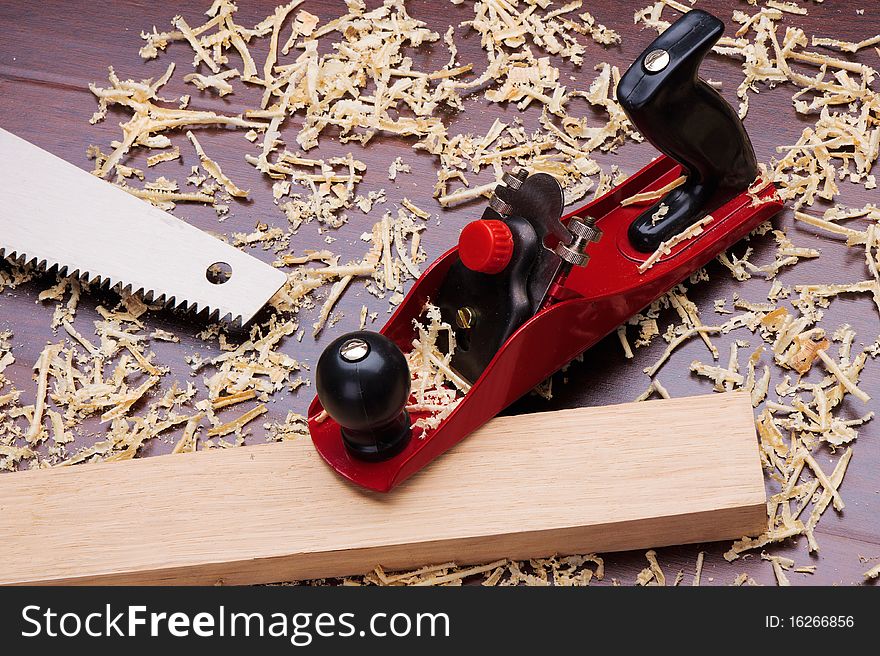 Red plane, wooden brick, handsaw and shavings