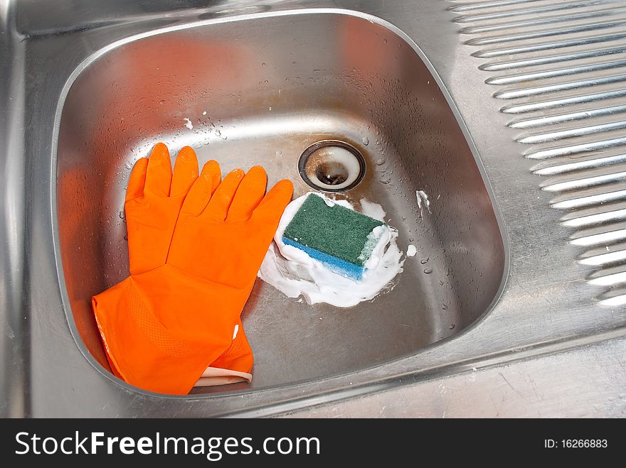 Cleaning the kitchen sink with a glove