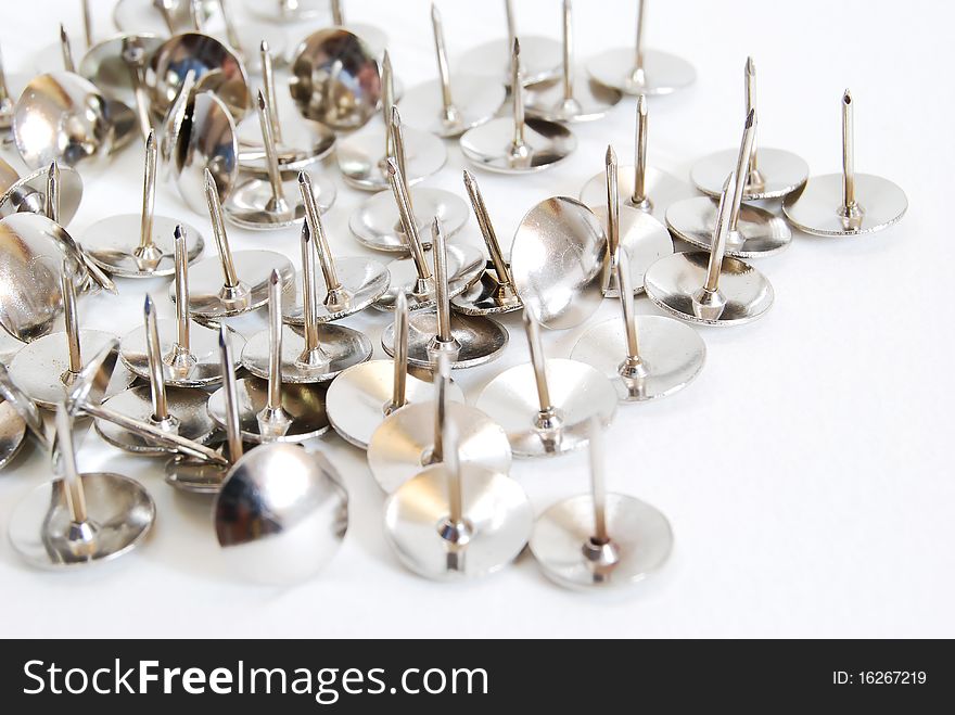 Many of metal thumbtacks on white background