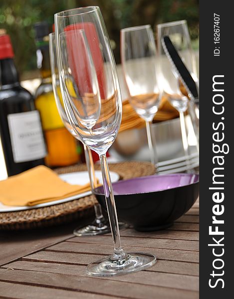 Glass of wine and wine bottle fading on background on garden table. Glass of wine and wine bottle fading on background on garden table