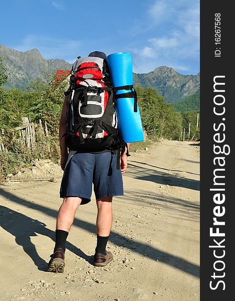 Tourist With A Large Backpack Is A High Mountain,