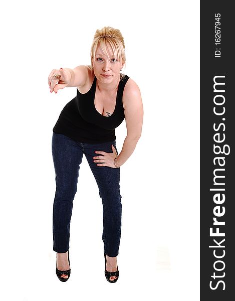 An pretty blond woman in jeans and a black tank top and high heels standing in the studio and pointing her finger, for white background. An pretty blond woman in jeans and a black tank top and high heels standing in the studio and pointing her finger, for white background.