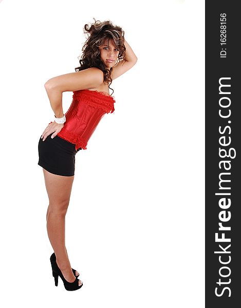 A beautiful young woman in a red corset and black shorts, with brunet
long curly hair and high heels standing in profile for white background. A beautiful young woman in a red corset and black shorts, with brunet
long curly hair and high heels standing in profile for white background.