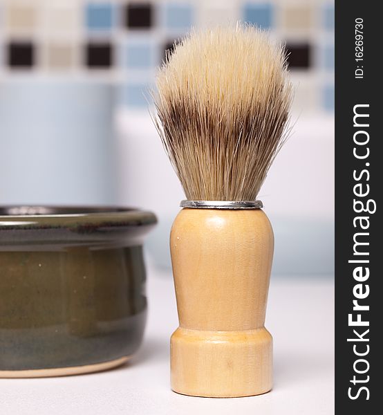 Closeup of a shaving brush and shaving soap mug