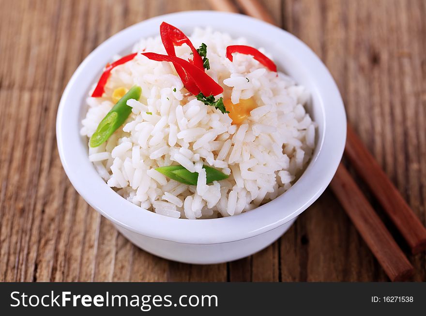 Bowl of cooked rice and wooden chopsticks