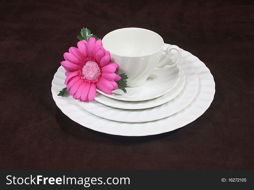 Crisp white set of dishes with a pink flower on the side