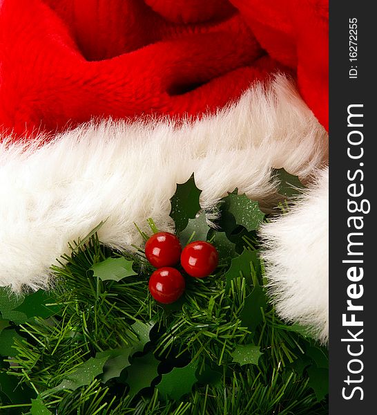 A close up of mistletoe with red berries and a christmas hat