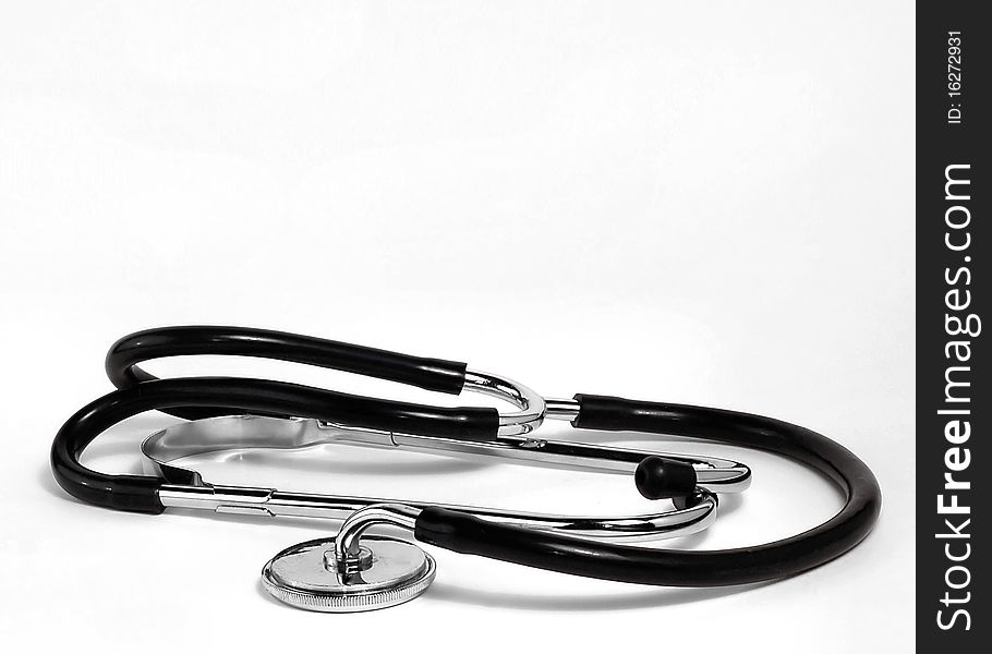 A doctors stethoscope rests on a white background. A doctors stethoscope rests on a white background