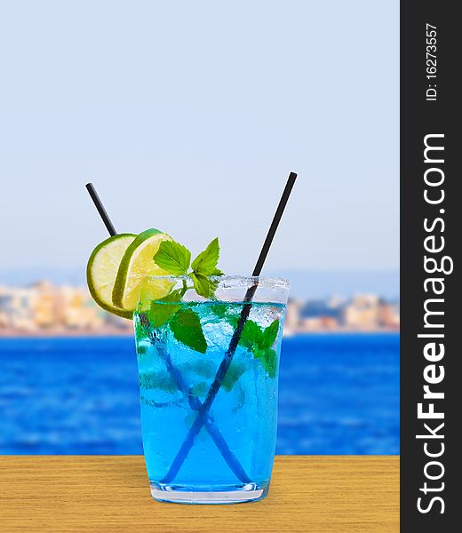 Cocktail on table in cafe - sea and town on background