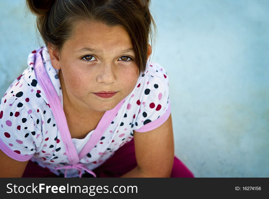 Cute little girl wearing polka dots on a patio. Cute little girl wearing polka dots on a patio.