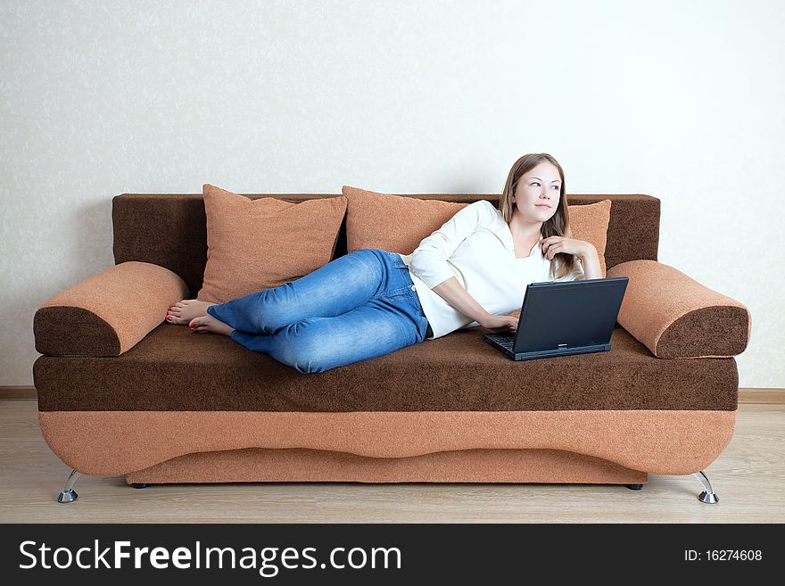 Young beatiful woman with laptop on the sofa