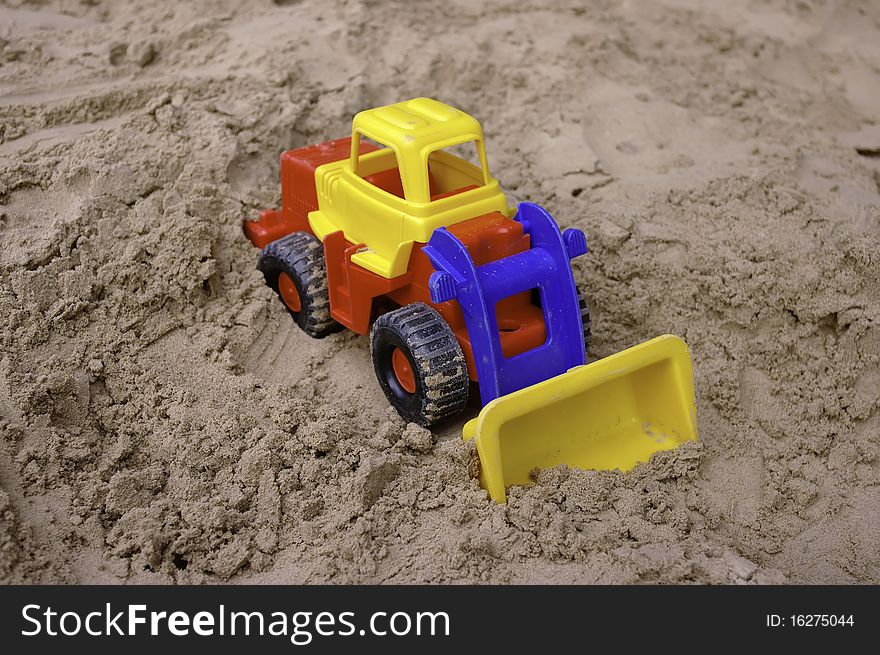 Plastic Toy Tractor On The Sand