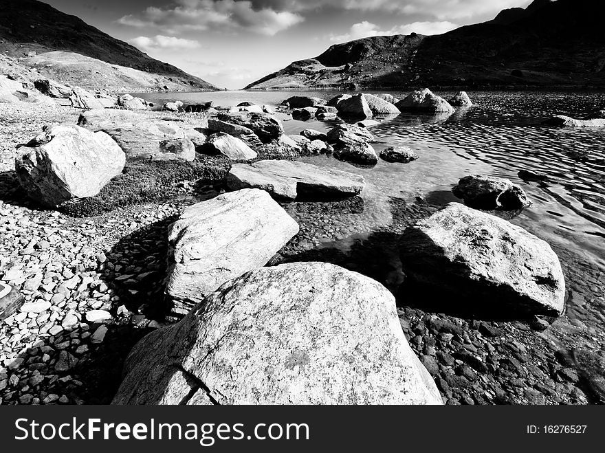 Close-up of rocks on the edge of of a mountain lake from foot level. Close-up of rocks on the edge of of a mountain lake from foot level