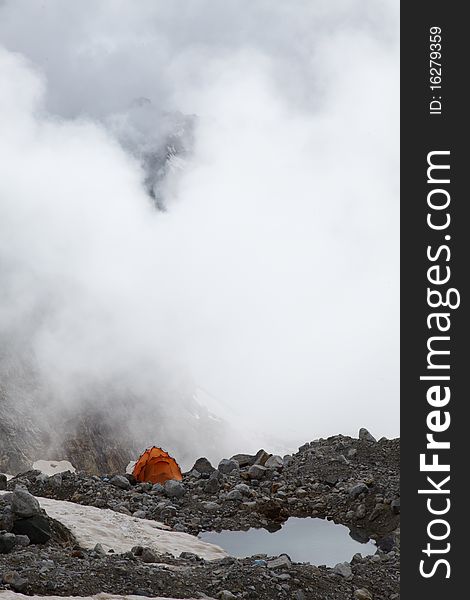 Orange tent near lake in the Caucasus mountains. Orange tent near lake in the Caucasus mountains