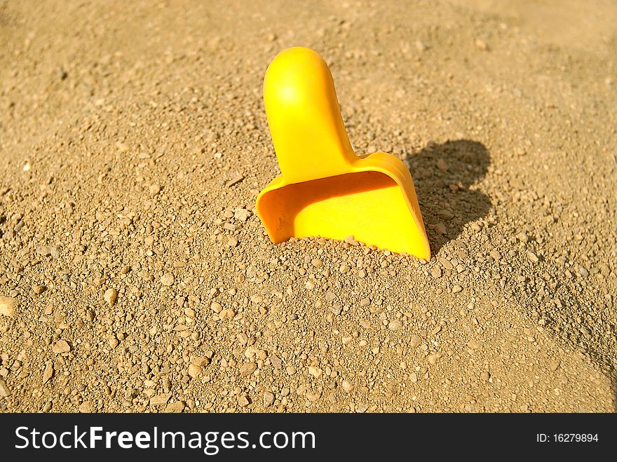 Children's yellow scoop will thrust in sand. Children's yellow scoop will thrust in sand