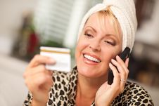 Smiling Robed Woman On Cell Phone With Credit Card Royalty Free Stock Images