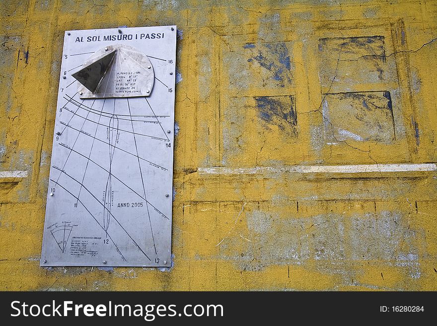 A sun dial of a mountain shelter in italy saying i count the steps of the sun