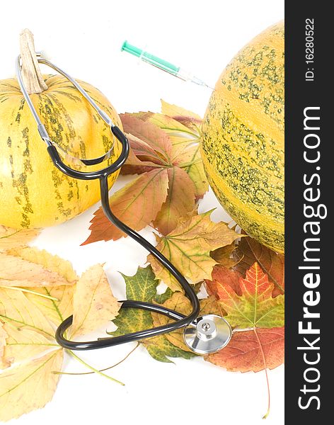 Two pumpkin and leafs with stethoscope and syringe