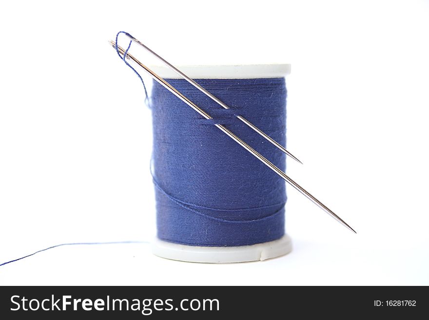 Two needles on a spool of cotton thread isolated over white background. Two needles on a spool of cotton thread isolated over white background