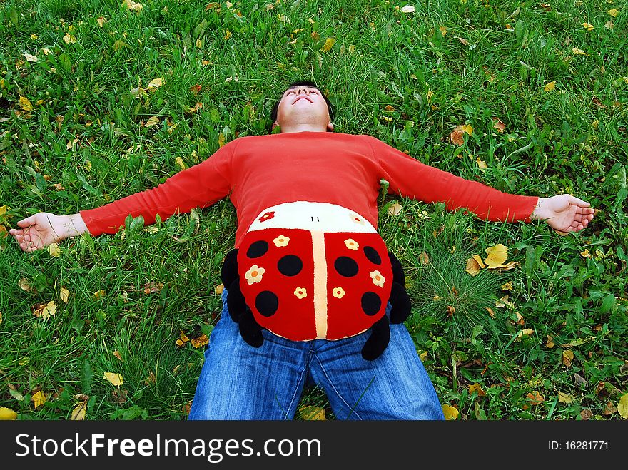 Photo of the young man having a rest on a grass