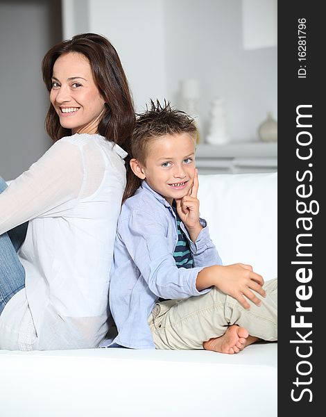 Little blond boy sitting on sofa with mom. Little blond boy sitting on sofa with mom