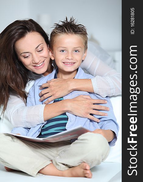 Mother And Child Reading Book At Home