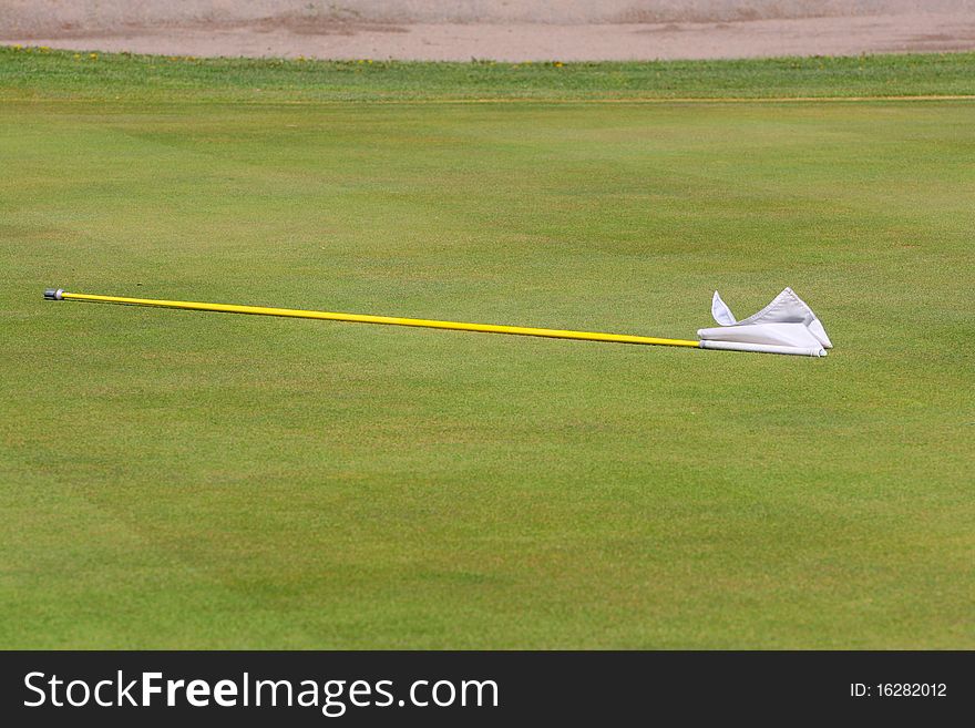 White putting greens flag lying on the green